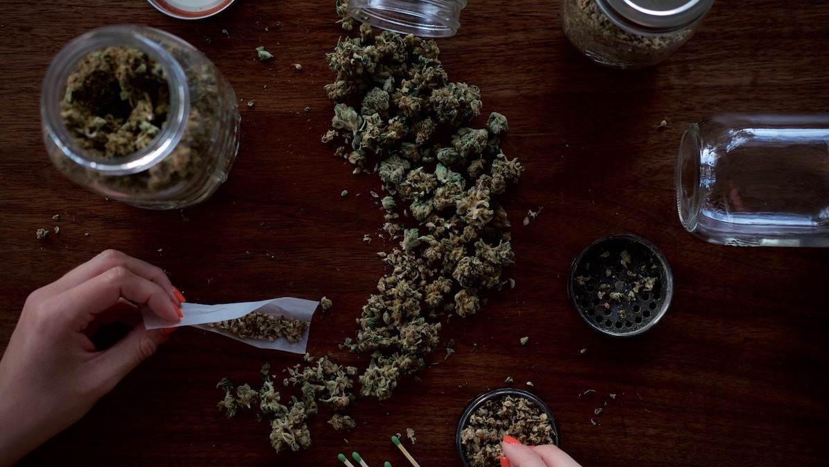 legal cannabis industry - jar of flower on table to roll a joint